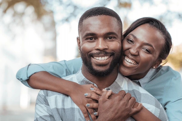 smiling-young-african-woman-hugging-600nw-763372366